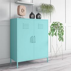 a blue cabinet sitting next to a potted plant