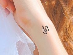 a woman's arm with a small tattoo on the left side of her wrist