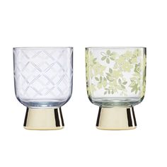 two glass vases sitting side by side on top of each other, one with green leaves