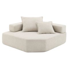 a white couch with two pillows on it's back and one pillow in the middle