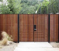 a wooden fence with black gate and grass