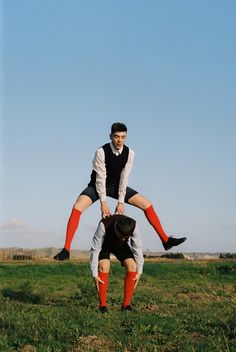 two men are playing with each other in the grass