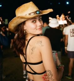 a woman wearing a cowboy hat at a music festival