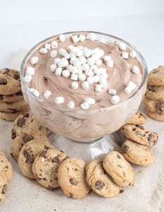 cookies and marshmallows are arranged around a bowl of chocolate pudding