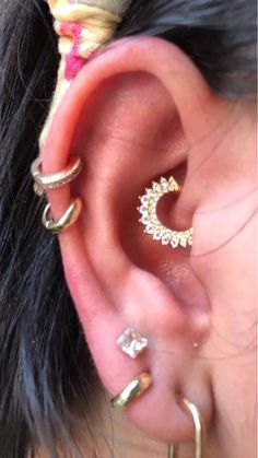 a close up of a person with ear piercings on their ears and behind the ear