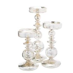 three clear glass candlesticks sitting next to each other