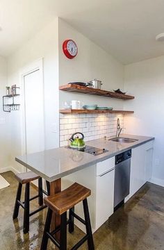 a kitchen with two stools next to the sink