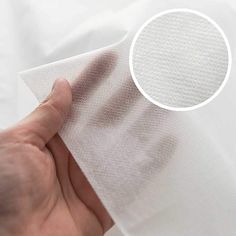 a hand holding a piece of white fabric