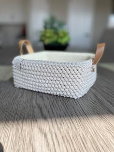 a white basket sitting on top of a wooden table