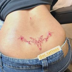 a woman's stomach with a tattoo on it that has pink flowers in the shape of a butterfly