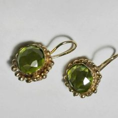 These unique beautiful short drop gold peridot earrings  are classic and romantic dangle earrings for women.  They are handmade with 18k solid gold vermeil thickly plated sterling silver. The design of the backings own a hammered texture. A Lustrous pair of  handmade round gold and gemstone earrings set with peridot, in an antique classic design. As an alternative to vermeil, they are available in Sterling Silver, 9k yellow solid gold, 14k yellow solid gold or 18K solid gold. These earrings could be worn as  everyday earrings or other occasions. They will be stunning every time you wear them. Peridot is August's vibrant birthstone and is great for summer. Can serve as wedding earrings, graduation gift or a birthday gift for women who were born in August. It is considered to enhance vitalit Elegant Green Brass Earrings, Elegant Faceted Brass Earrings, Delicate Faceted Gold Earrings, Dainty Faceted Yellow Gold Earrings, Peridot Earrings, Earrings Handmade Dangle, Gold Dangle Earrings, August Birthstone, Handmade Jewelry Designs