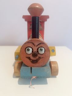 a wooden toy train with a face painted on it