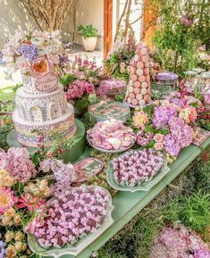 a table filled with lots of flowers and cakes