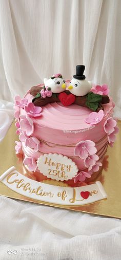 a pink cake with two birds on top