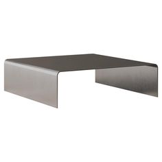 a metal table that is on top of a white wall and has a black surface