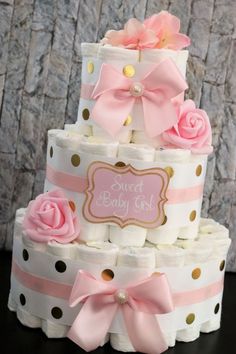 a three tiered baby shower cake with pink and gold polka dots on the bottom