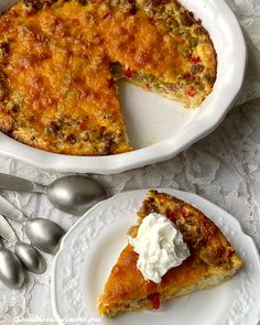 a piece of quiche on a plate with a fork and spoon next to it