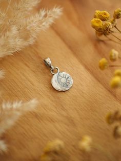 "Minimalist sterling silver charm pendant in a round shape with solar eclipse motif: a Sun and crescent moon. Finished with raw texture made of silver dust witch makes each charm slightly different and unique.  All elements were darkened and polished to enhance the details. A minimalist trinket for romantics, nature lovers and modern witches. It will work well as your daily basis necklace as well as an accessory to a party stylization. Materials: sterling silver; Measurements: - charm: about 0.4 Sterling Silver Sun And Moon Round Pendant Jewelry, Minimalist Sterling Silver Jewelry With Sun Design, Silver Moon Phase Disc Jewelry, Silver Moon Phase Round Disc Jewelry, Sun And Moon Pendant, Raw Texture, Celestial Pendant, Modern Witch, Solar Eclipse