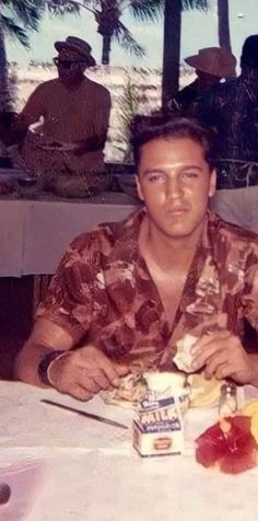 a man sitting at a table with food in front of him