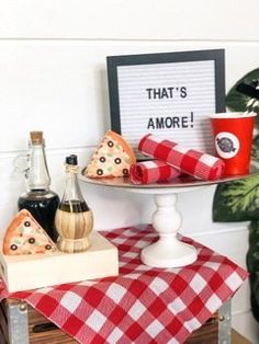 there are pizza slices on the table with red and white checkered cloth