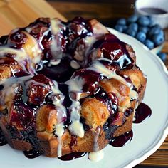 a bundt cake with blueberries and icing on a plate