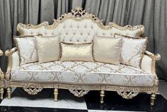 an ornate couch with gold and white pillows