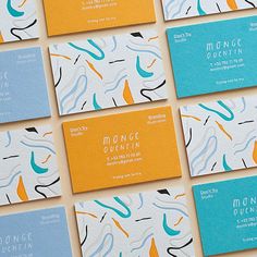 many business cards are arranged on top of each other, with different colors and shapes