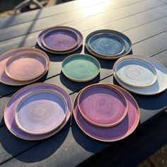 a table topped with lots of different colored plates