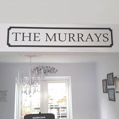 there is a sign that says the murrays above a bed in a room with pictures on the wall