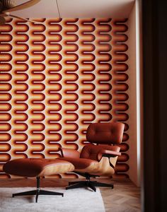 an eames lounge chair and ottoman in front of a wall with circles on it