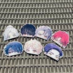 six anime character stickers sitting on top of a metal grill grate, each with different colored hair colors