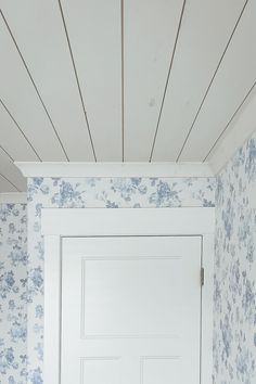 a white door in a room with blue wallpaper