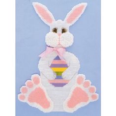 a white rabbit with pink and purple stripes on it's chest, holding a rainbow ball in its paws