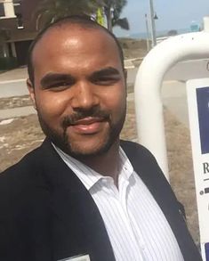 a man is standing next to a sign