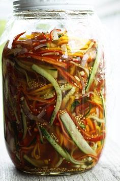 a jar filled with sliced vegetables sitting on top of a table