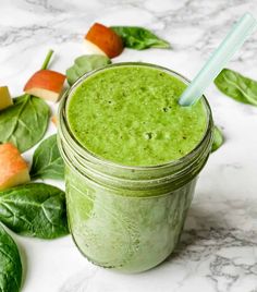 a green smoothie in a mason jar with a straw