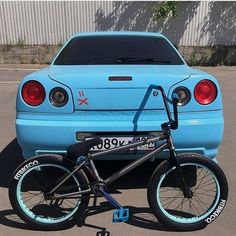 a blue car is parked next to a bicycle