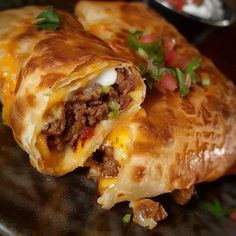 a close up of a burrito on a plate with other food items in the background