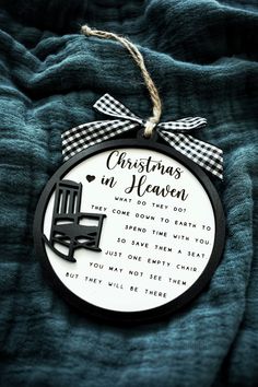 a black and white ornament hanging from a blue blanket with a plaid ribbon