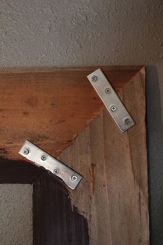 two metal hinges on the side of a wooden door