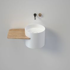 a white sink sitting on top of a wooden counter next to a wall mounted faucet