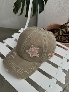 a brown hat sitting on top of a white bench next to a potted plant