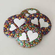 three decorated rocks with white hearts on them