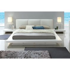 a white bed sitting in the middle of a bedroom