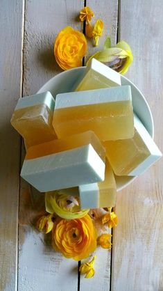 soap and flowers on a wooden table with white boards in the background, including yellow roses