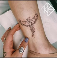 a woman's foot with a bird tattoo on it