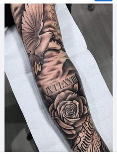 a person with a bird and roses tattoo on their arm is sitting in a chair