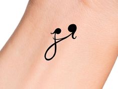 a small tattoo on the arm of a woman's left arm with an x and j symbol