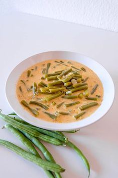 a white plate topped with green beans and soup