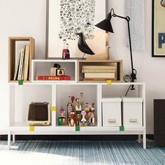 a white shelf with books and other items on top of it in a living room